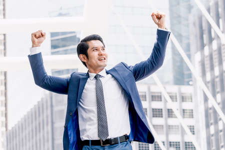 Successful businessman celebrating with arms upの写真素材