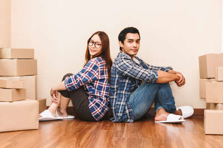 Happy couple with cardboard box at new homeの写真素材