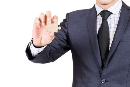Businessman holding wood jigsaw piece isolated on white backgroundの写真素材