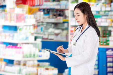 Woman pharmacist at work on blur pharmacy backgroundの写真素材