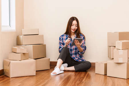 Young woman with cardboard box at home - Business online and delivery concept