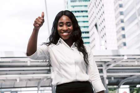 African woman show thump up on office building backgroundの写真素材