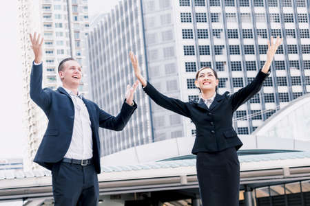 Successful business people celebrating with arms up