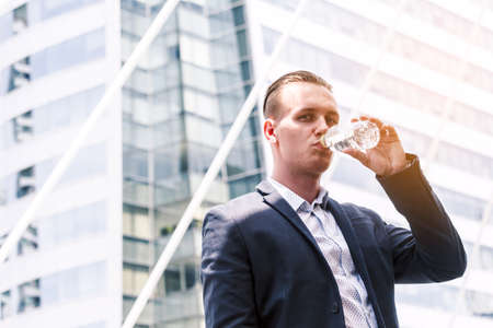 Businessman drinking mineral water from bottleの写真素材