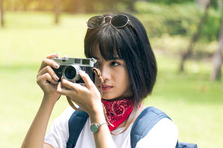 Asian woman taking picture with camera
