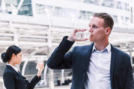Businessman drinking mineral water from bottleの写真素材