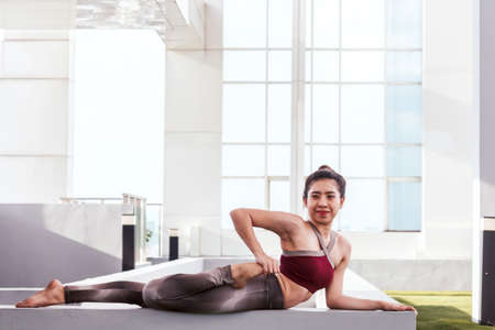 Woman practicing yoga  in front of a large windowの写真素材