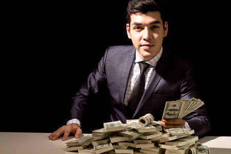 Businessman holding Dollars on black background