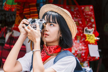 Asian woman taking picture with camera