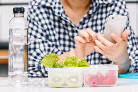 Mother making healthy school lunch box for her children