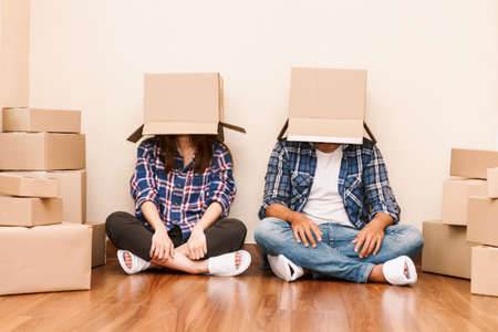 Happy couple with cardboard box at new home
