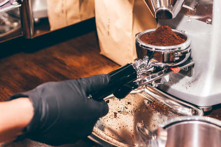 Women Barista using coffee machine for making coffee in the cafe