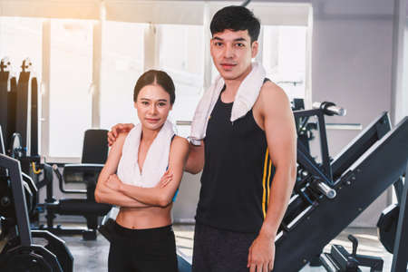 Sport man and woman with towel stand at the gym.fitness and lifestyle concept