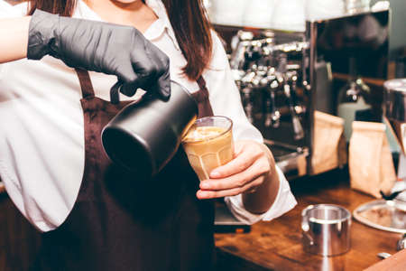 Barista holding milk for make coffee latte art in coffee shopの写真素材