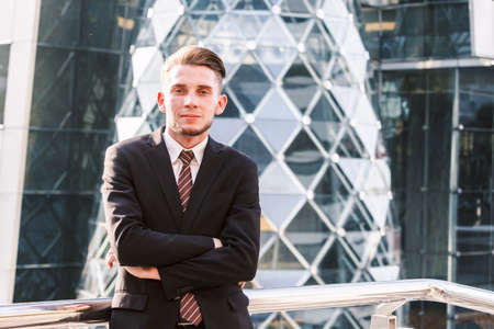 Portrait of handsome man in black suit standing outdoors