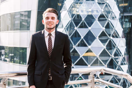 Portrait of handsome man in black suit standing outdoors