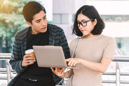 Two teenager students doing homework with laptop at university