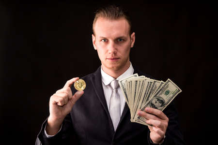 Businessman holding bitcoin on black background