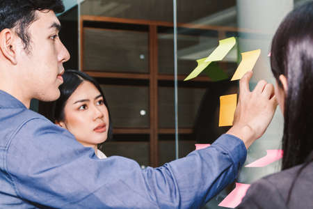 Businessman point with sticky notes on glass window