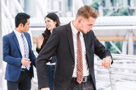 Businessman looking at watch at office buildingの写真素材