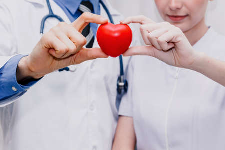 Doctor and nurse red heart in hand.heart attack or disease conceptの写真素材