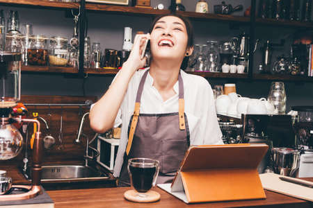 Barista woman using digital tablet compute in coffee shop counter barの写真素材