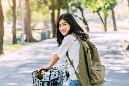 Woman with bicycle in the gardenの写真素材