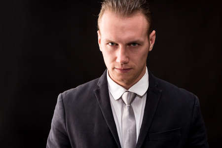 Portrait of handsome businessman on dark background