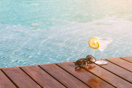 Cocktail with fresh lemon on swimming pool backgroundの写真素材