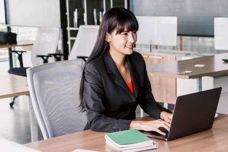 Businesswoman working on notebook computer and business document at office