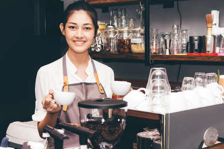 Barista holding coffee in coffee shopの写真素材