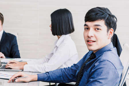 Businessman in the office with group of business people meeting in the backgroundの写真素材