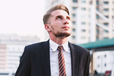 Portrait of handsome man in black suit standing outdoorsの写真素材