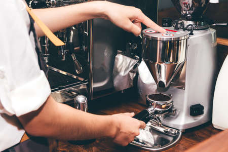 Women Barista using coffee machine for making coffee in the cafeの写真素材