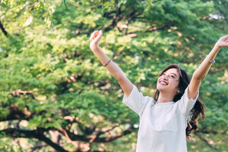 Woman standing stretch her arms relax and enjoy with nature fresh airの写真素材