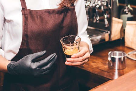 Barista holding coffee in coffee shopの写真素材
