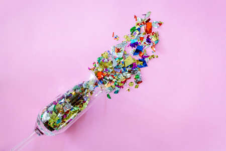 Colorful celebration with champagne glasses and colorful paper on pink background..flat lay, top viewの写真素材