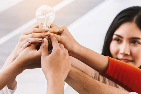 Business teamwork holding Light bulb - Team work conceptの写真素材