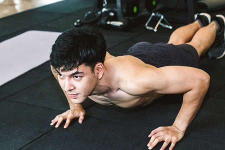 Man doing push ups exercise in fitness gym