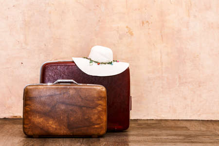 Vintage brown traveling luggage on wall background. Travel suitcases conceptの写真素材