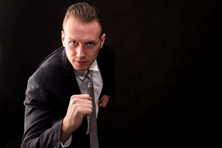 Businessman running forward isolated on black backgroundの写真素材