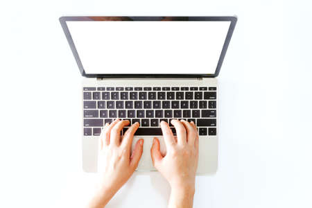 Top view of hand use laptop computer with blank screens on white office desk table.Flat lay