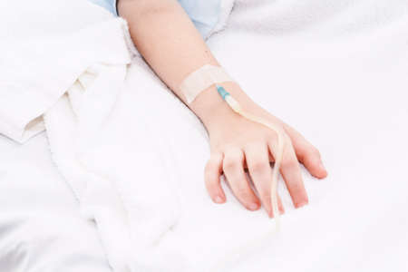 Little girl hand with IV saline intravenous in hospitalの写真素材