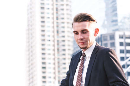 Portrait of handsome man in black suit standing outdoorsの写真素材