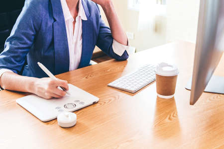 Woman graphic designer working with computer and drawing on graphic tablet at the office.Graphic Designer creativity conceptの写真素材