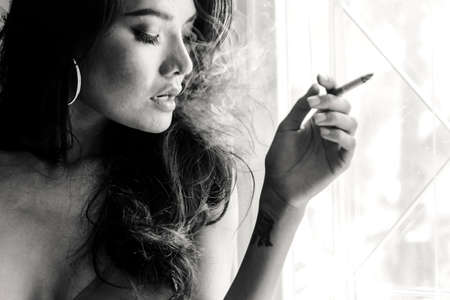 Fashion portrait of  beautiful woman sexy slim body smoking cigaretteの写真素材