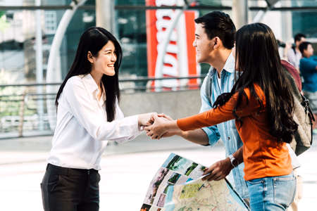 Group of young friends tourists standing and holding map in city.Traveler conceptの写真素材