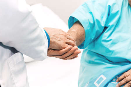 Doctor holding elderly person patient hand with care and consulting in hospital.healthcare and...