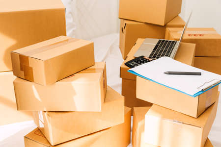 Pile of cardboard box and laptop computer on bed.Business online and delivery concept