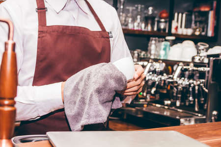 Barista holding coffee in coffee shopの写真素材